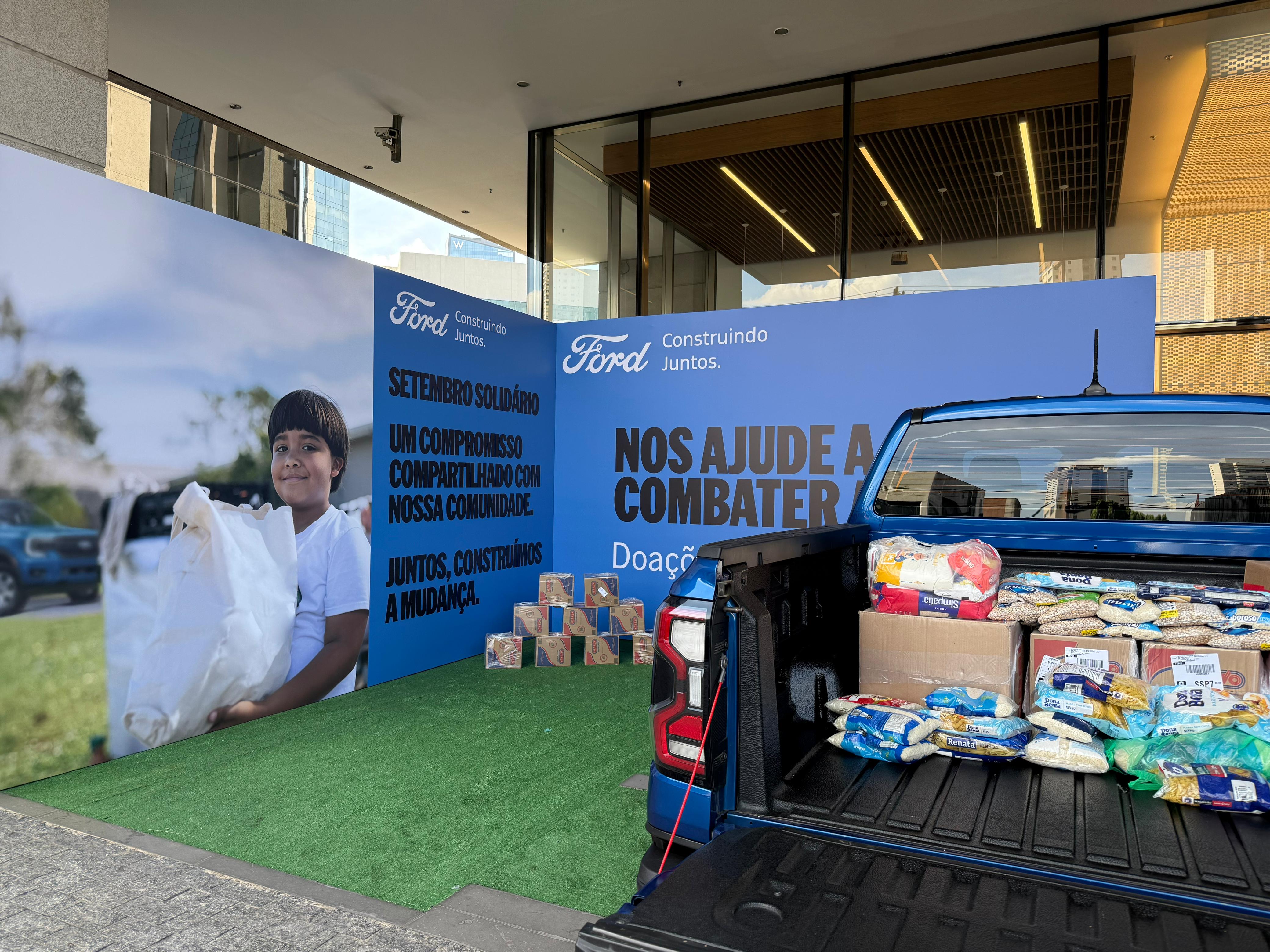 The cab of a truck is filled with donated food supplies inside a Ford dealership.